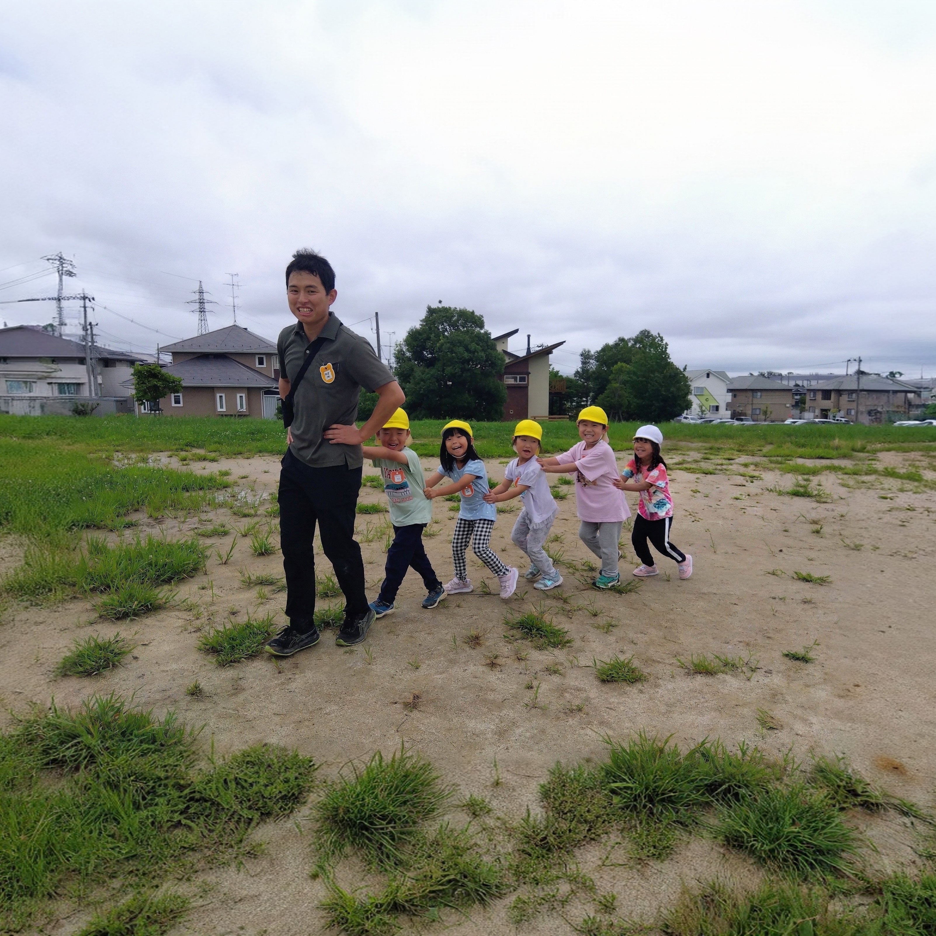 先頭に大人、その後ろを子どもたちが一列に連なって電車ごっこをしている