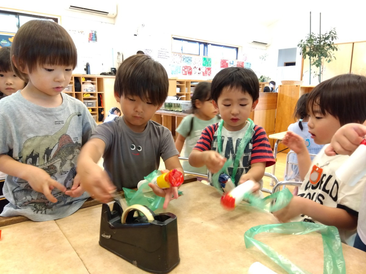 子どもたちはトイレットペーパー芯に色セロファンをテープで貼り付けている