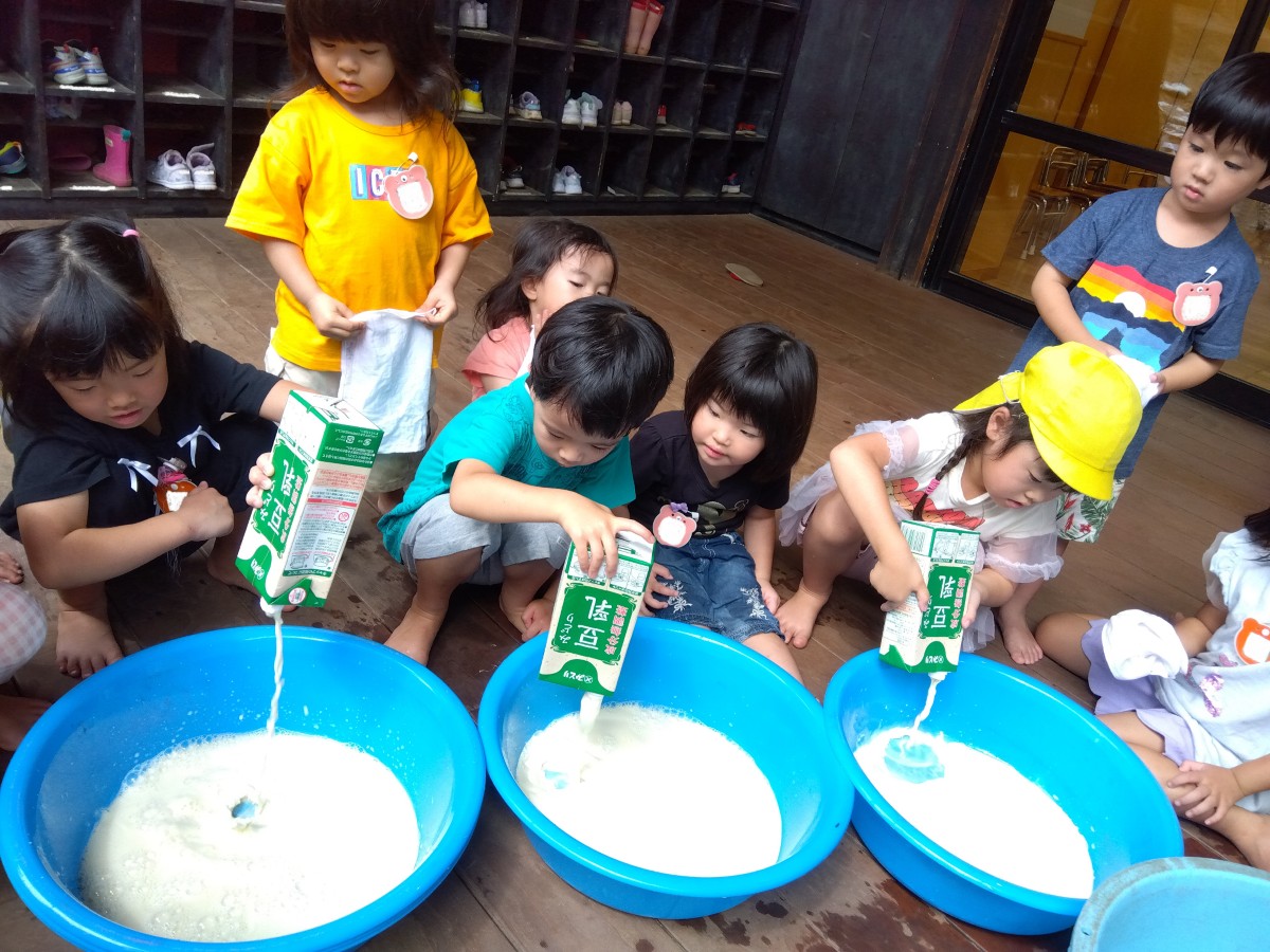 子どもたちは、大きなたらいに豆乳を入れている