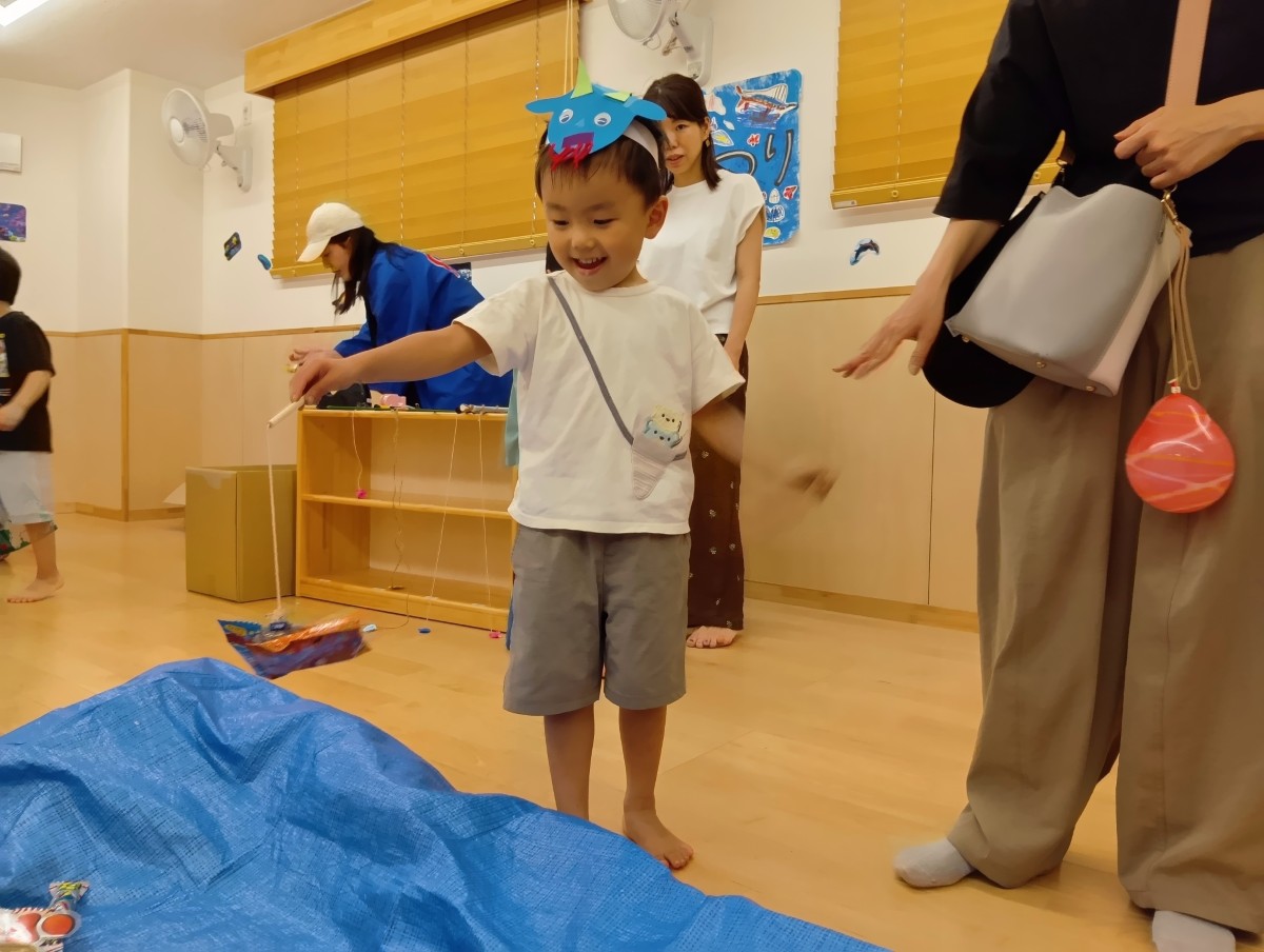 ヤギのお面を着けた子どもが、魚釣りを楽しんでいる