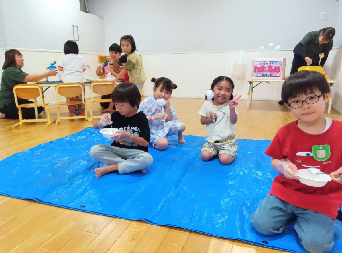 室内のブルーシートの上では、子どもたちがわたあめやかき氷を笑顔で食べている