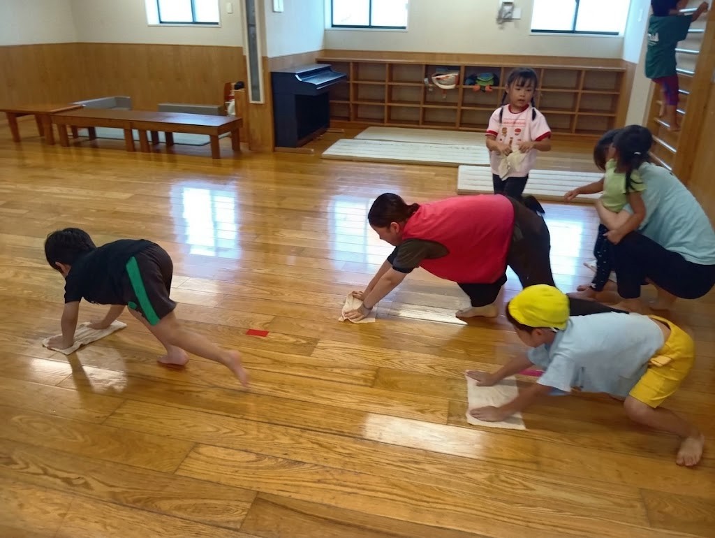 室内では、小学生と大人が雑巾がけをしている