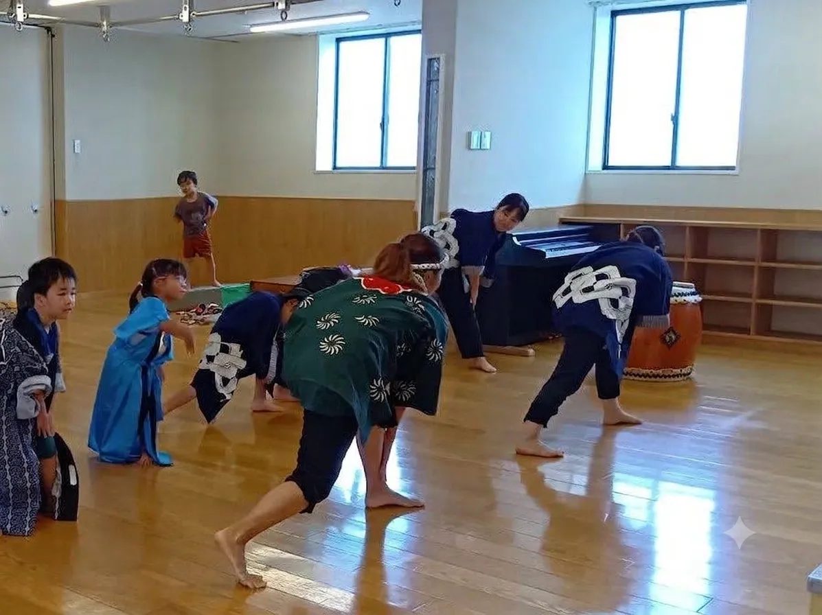 室内では、法被を着た大人と子どもたちが踊っている