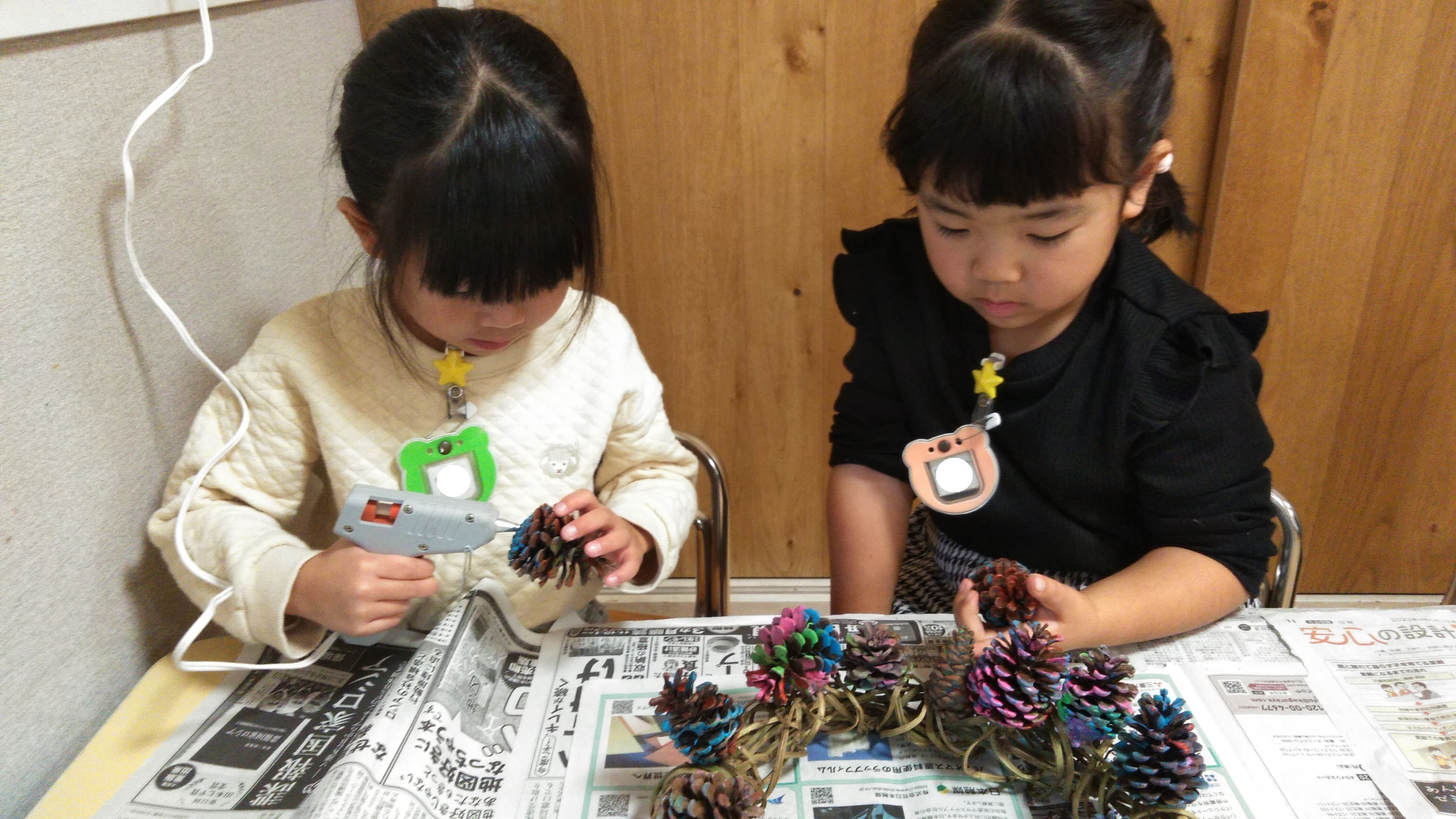 松ぼっくりをリースに付ける子どもたち