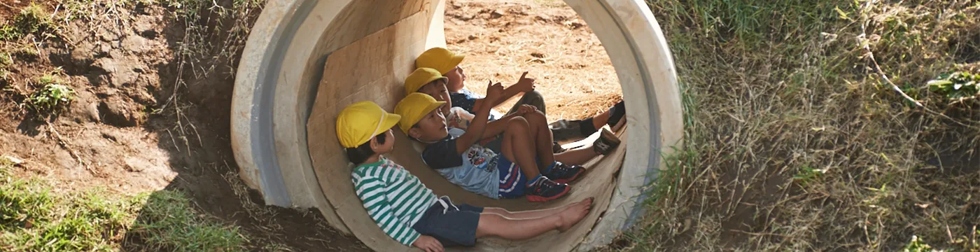 Children playing inside a concrete pipe