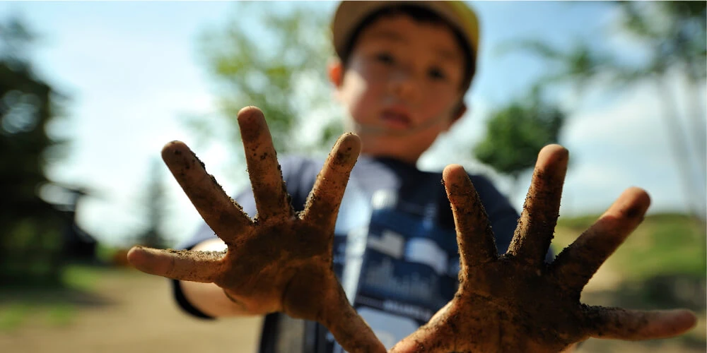 Muddy hands held up to the camera