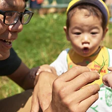 スタッフと草を観察する子ども