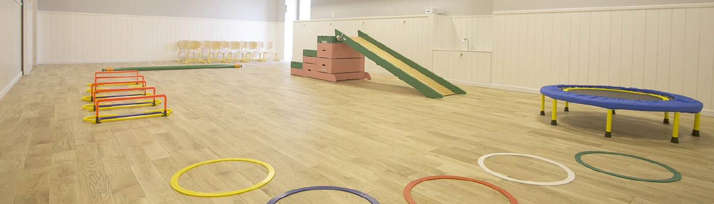Activity room with a slide, trampoline, and other play equipment