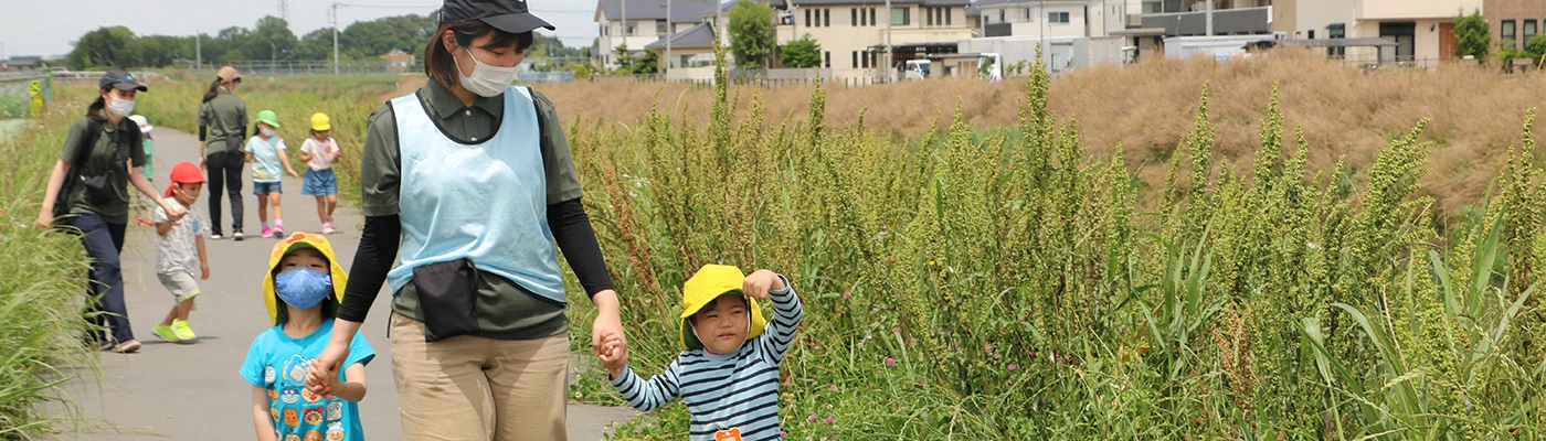 Staff members walking hand in hand with children