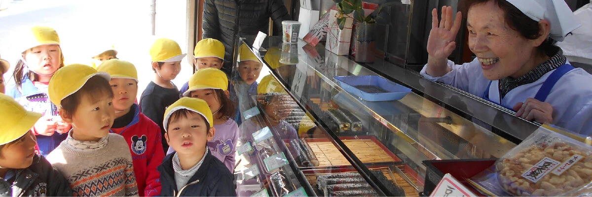 Children visiting a local shop and talking with the shopkeeper