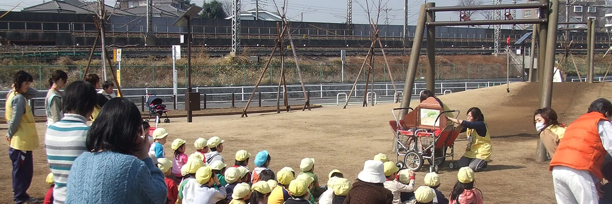 Local parents and children gathering with nursery staff at a park