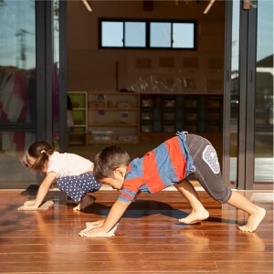 Children doing a crawling exercise indoors