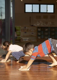 Children doing a crawling exercise indoors