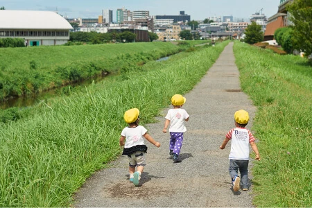 Children in yellow hats walking along a path