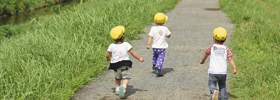 Children in yellow hats walking along a path