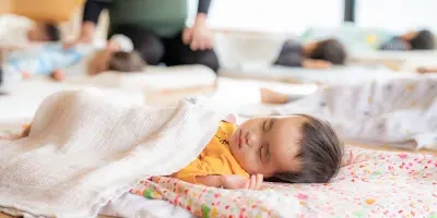 A child taking a nap under a blanket