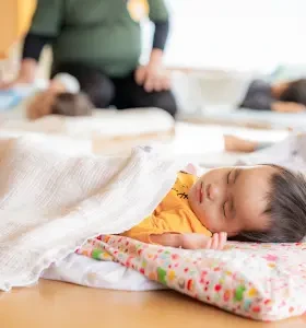 A child taking a nap under a blanket