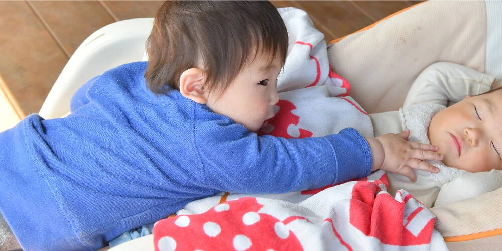 A child touching a sleeping child