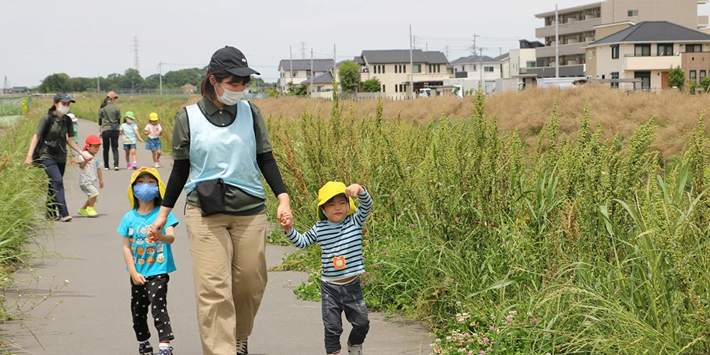 Children walking hand in hand with a staff member