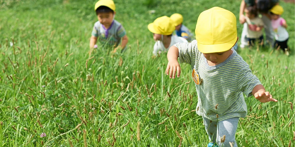 Children walking through a grassy field