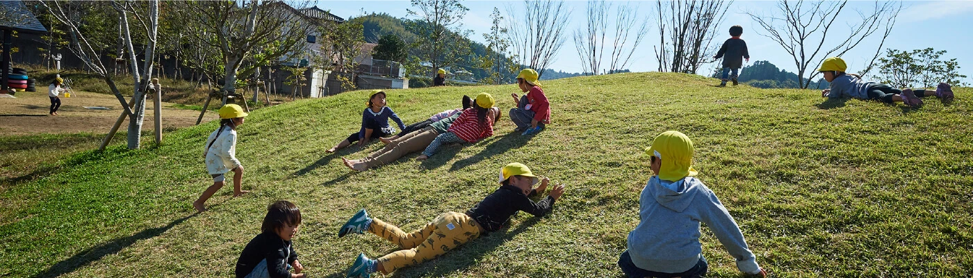 Children playing on a grassy hill