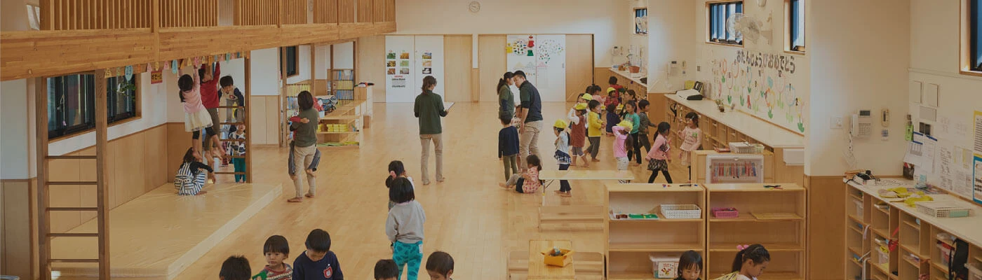 木造の保育室で遊ぶ子どもたちとスタッフ
