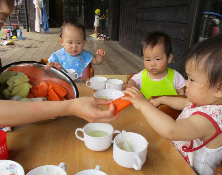 Children eating vegetables with their hands