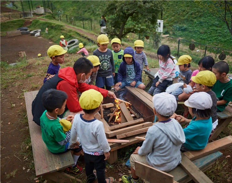 Children and staff gathered around a bonfire