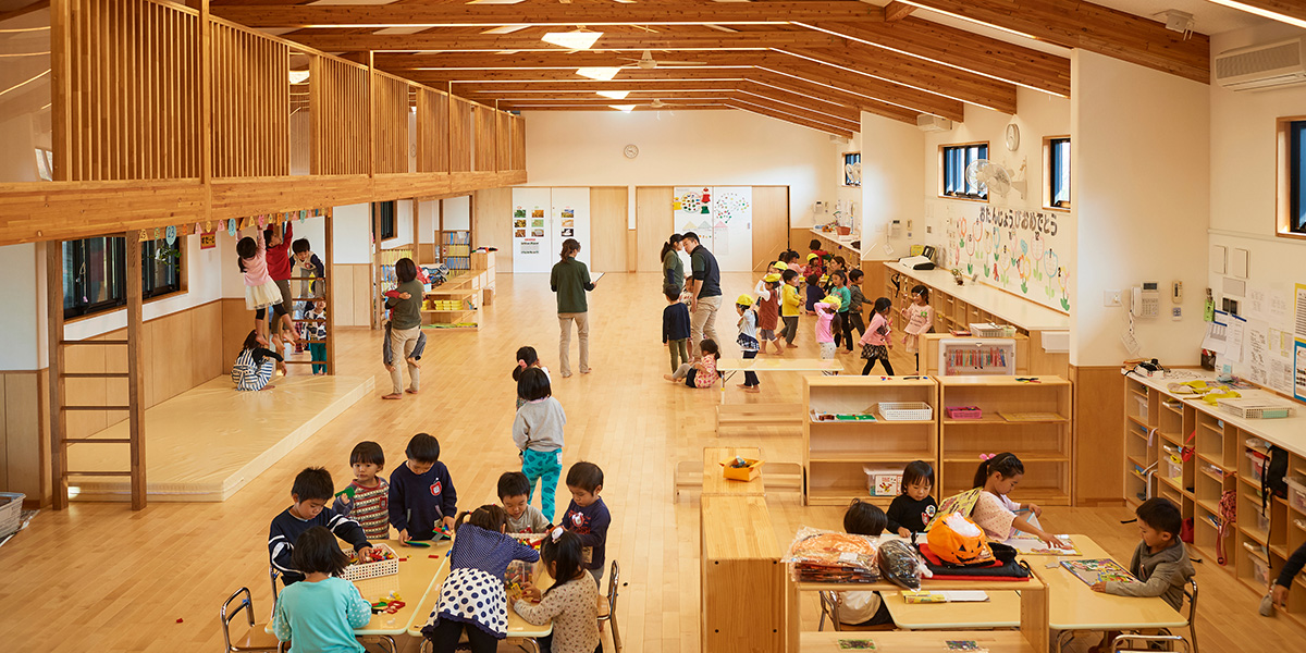 木造の保育室で遊ぶ子どもたちとスタッフ