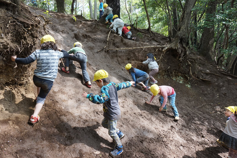 急な泥坂を登る子どもたち