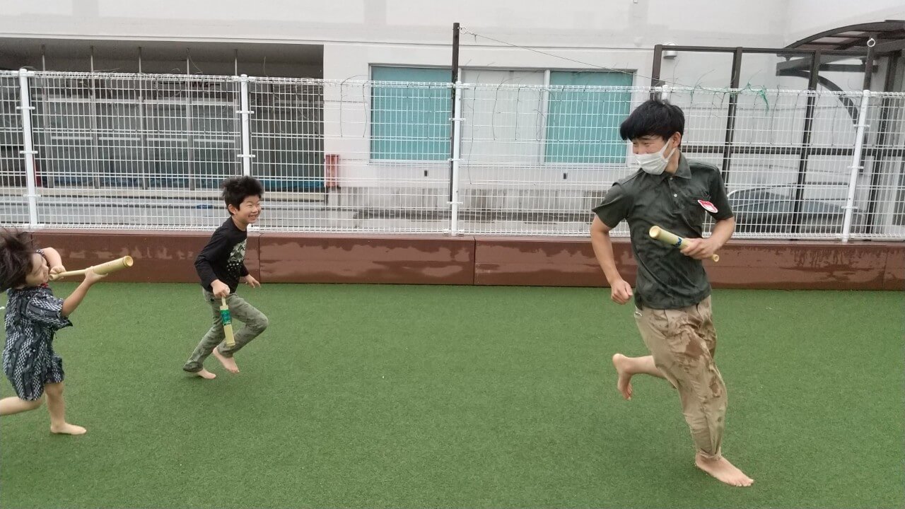 水鉄砲で遊ぶ職員と子ども