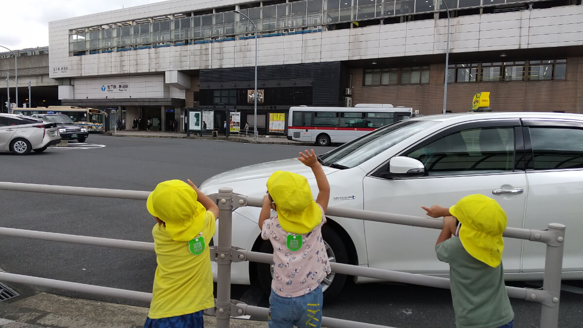 タクシーに手をふる子どもたち