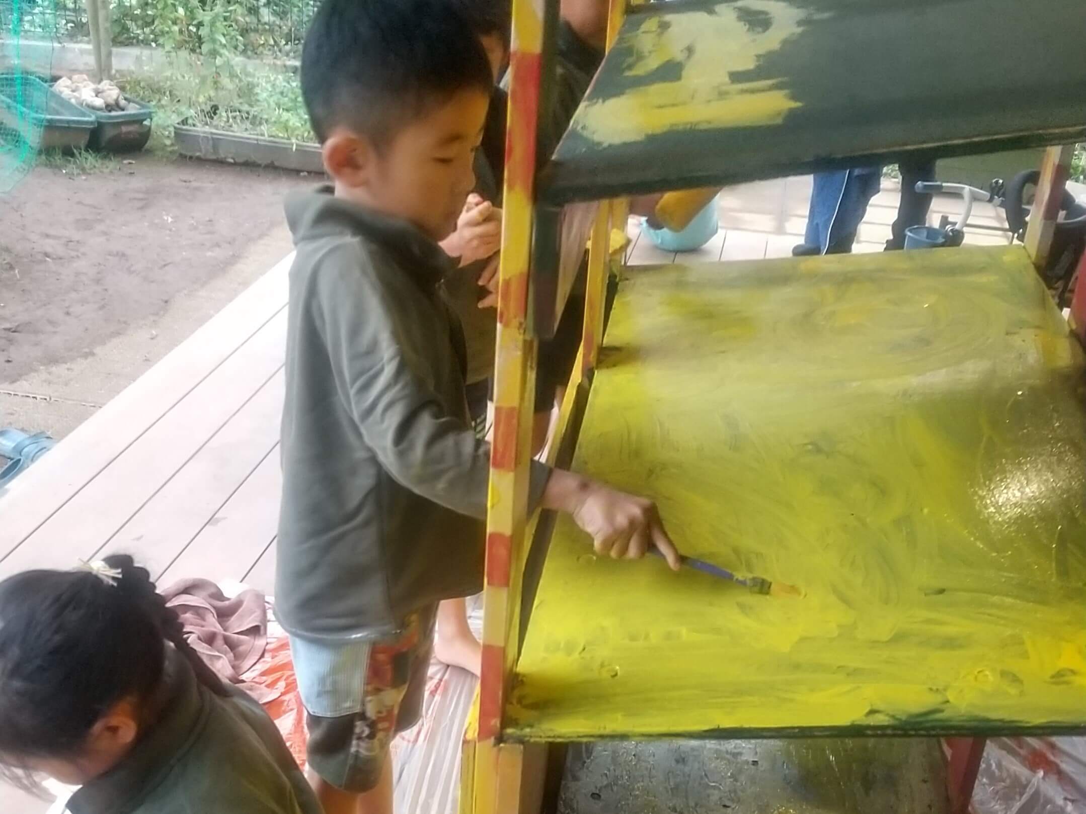 屋台を塗装する子ども