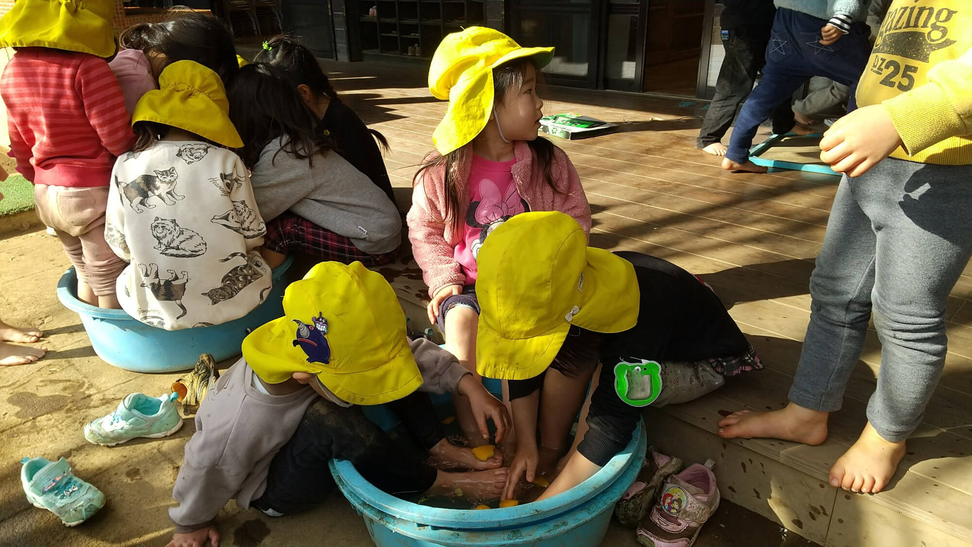 園庭で足湯をする子どもたち