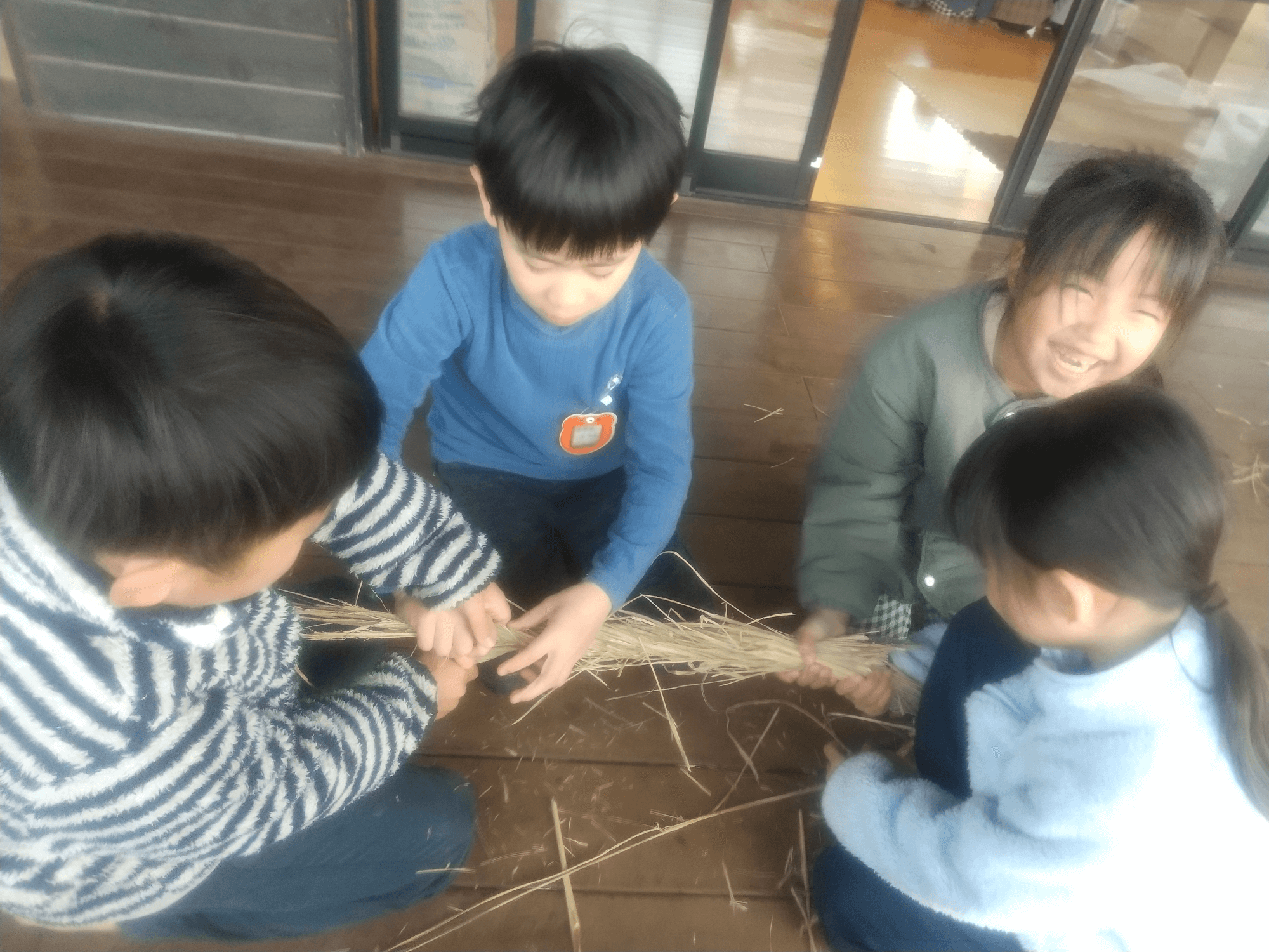 土俵に使う藁を編む子どもたち