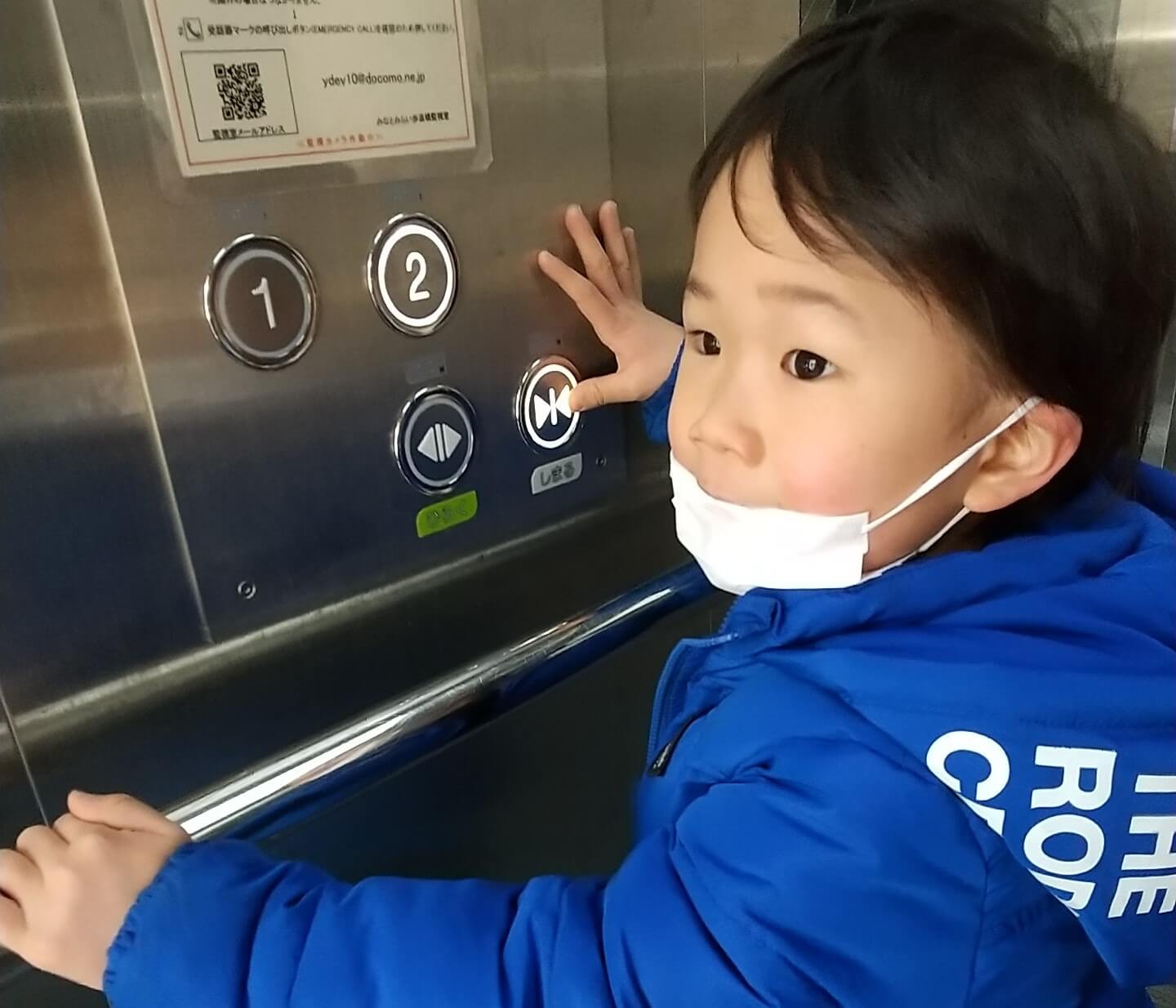 エレベーターのボタンを押す子ども