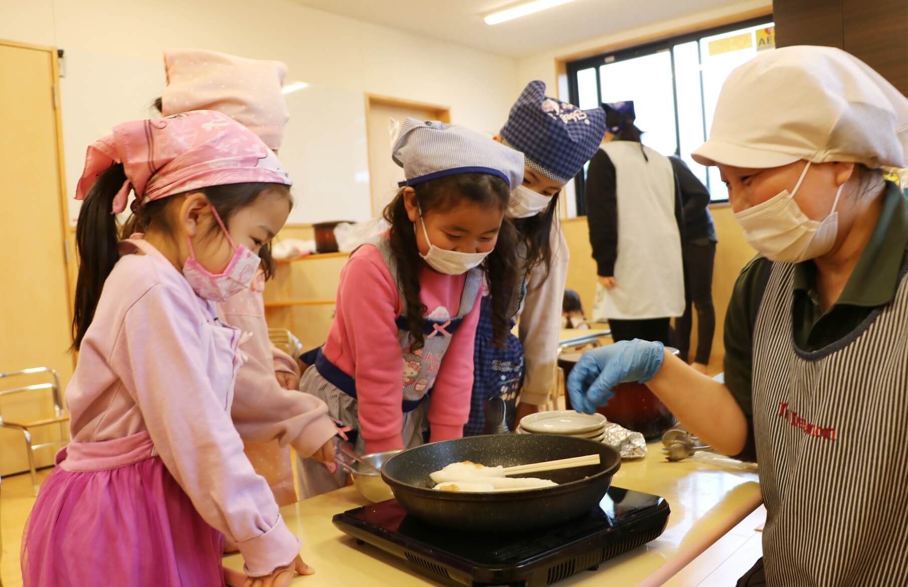 子どもたちと楽しそうに調理する三井さん