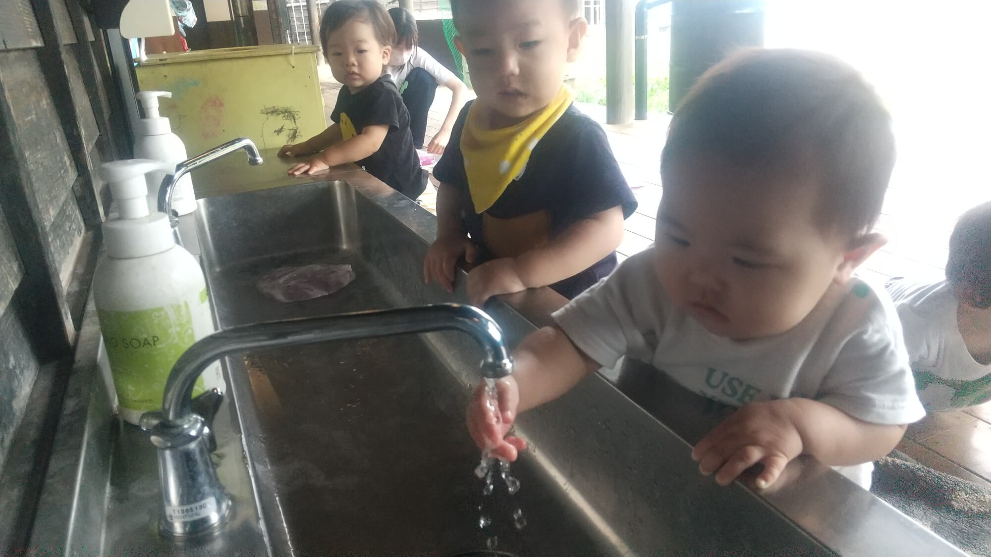 水道で手を洗う子ども