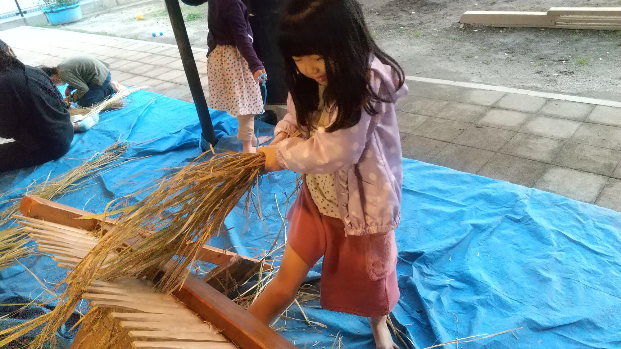 籾とりをする子ども