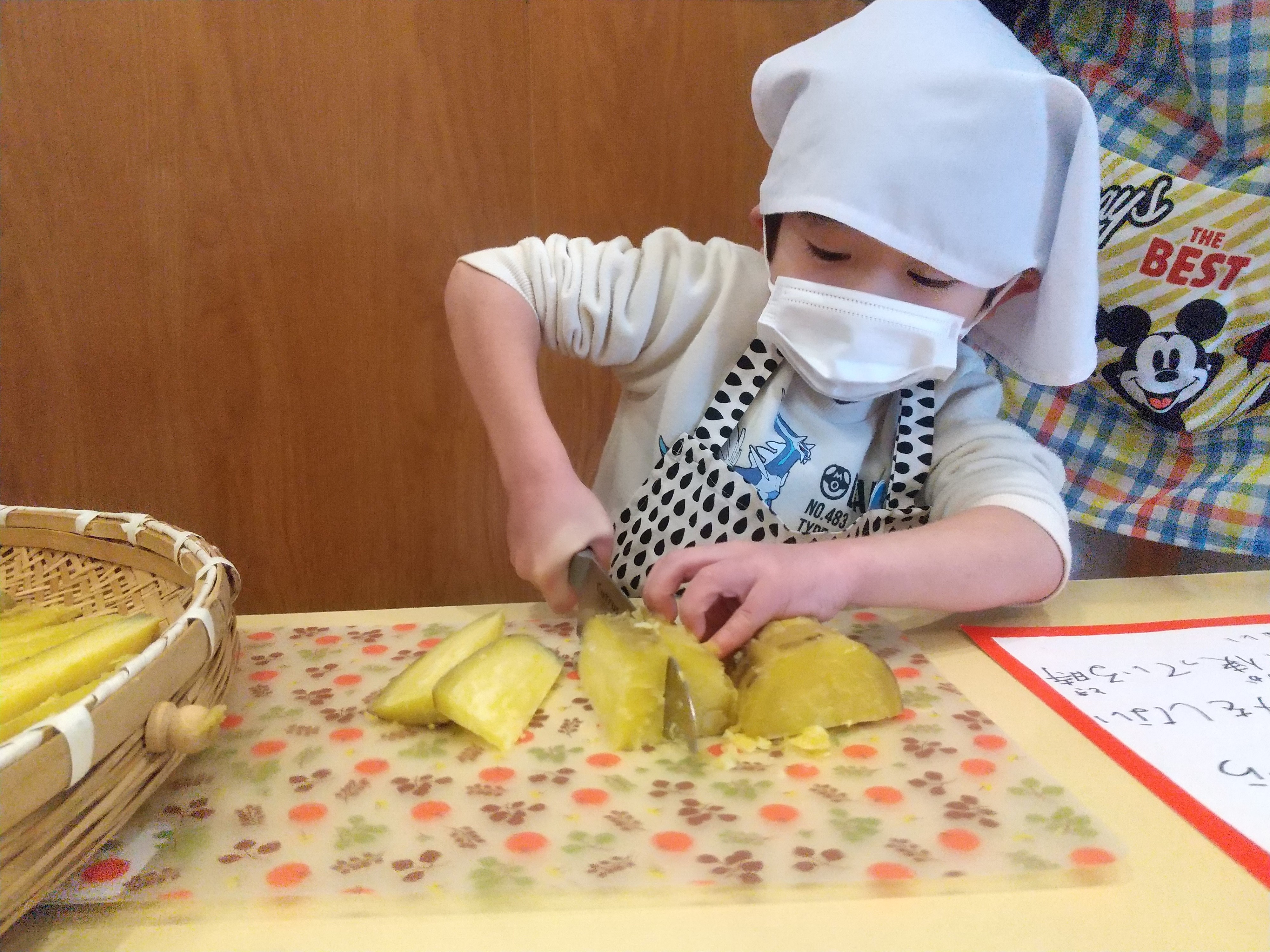 包丁を使ってサツマイモを切る子ども