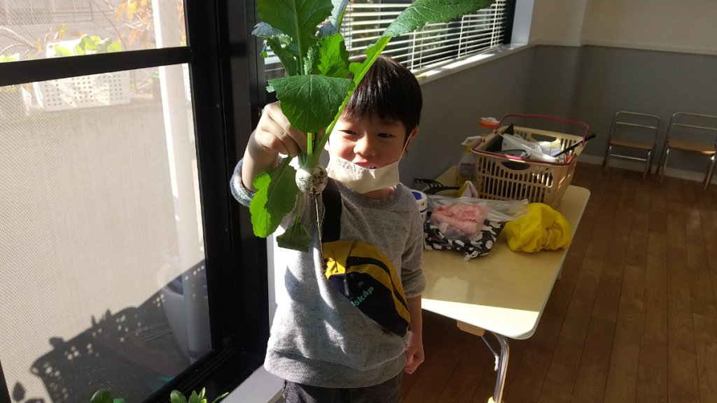 収穫した野菜を手にする子ども