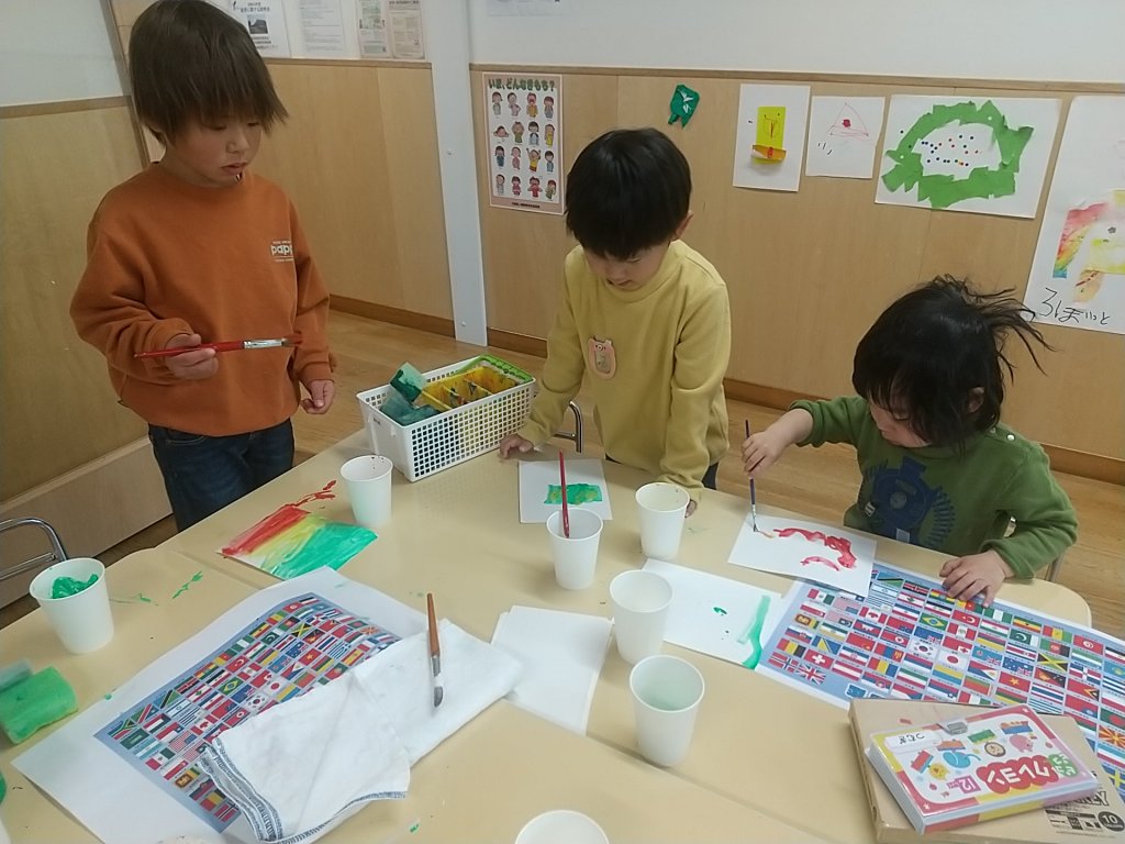 絵の具で国旗を描く子どもたち
