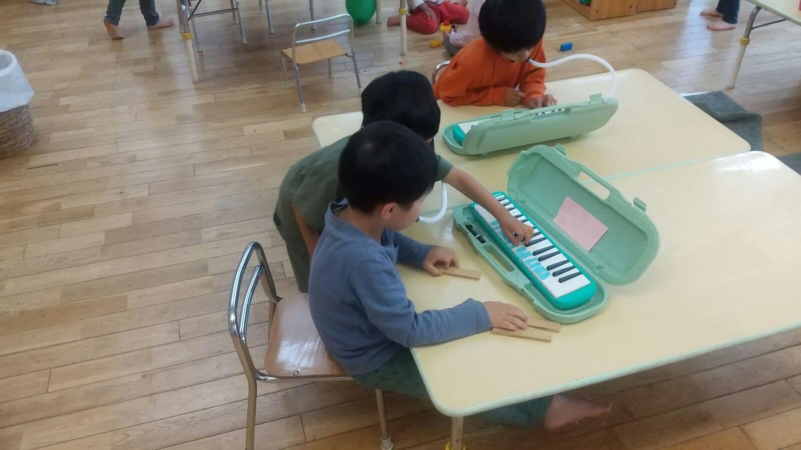 一緒に鍵盤ハーモニカを練習する子どもたち