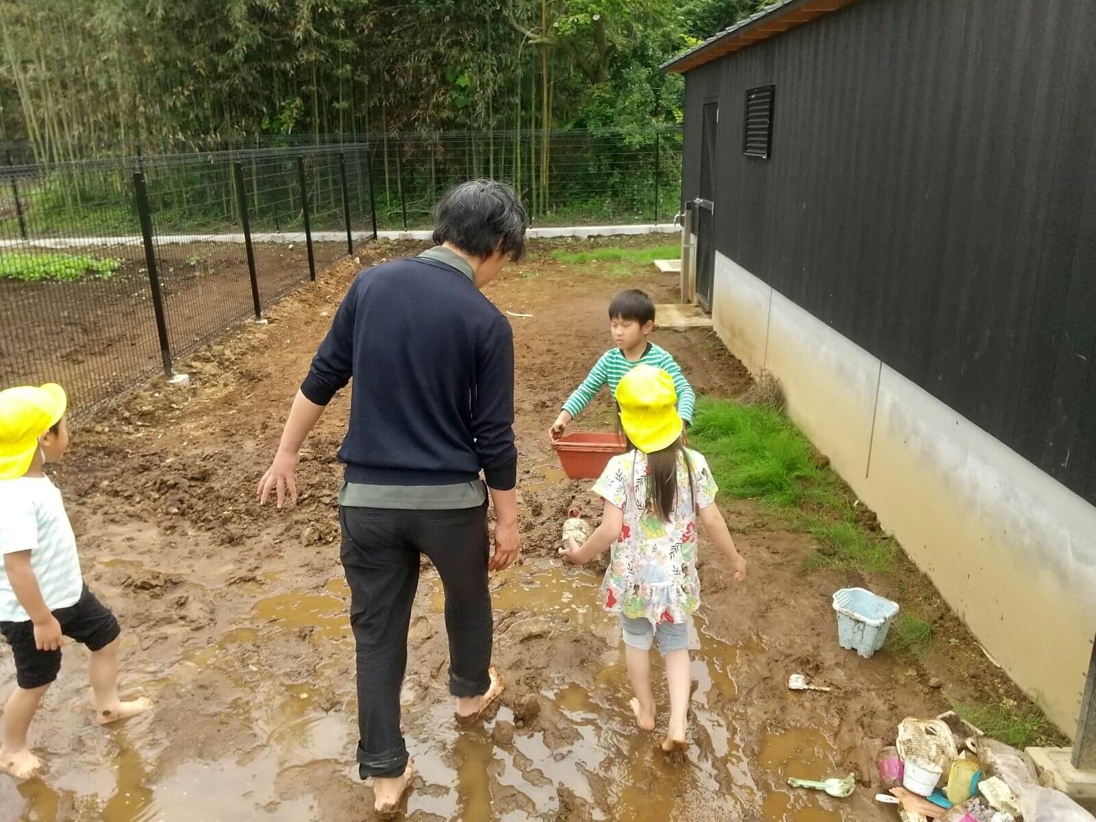 外で泥遊びをする子どもたち