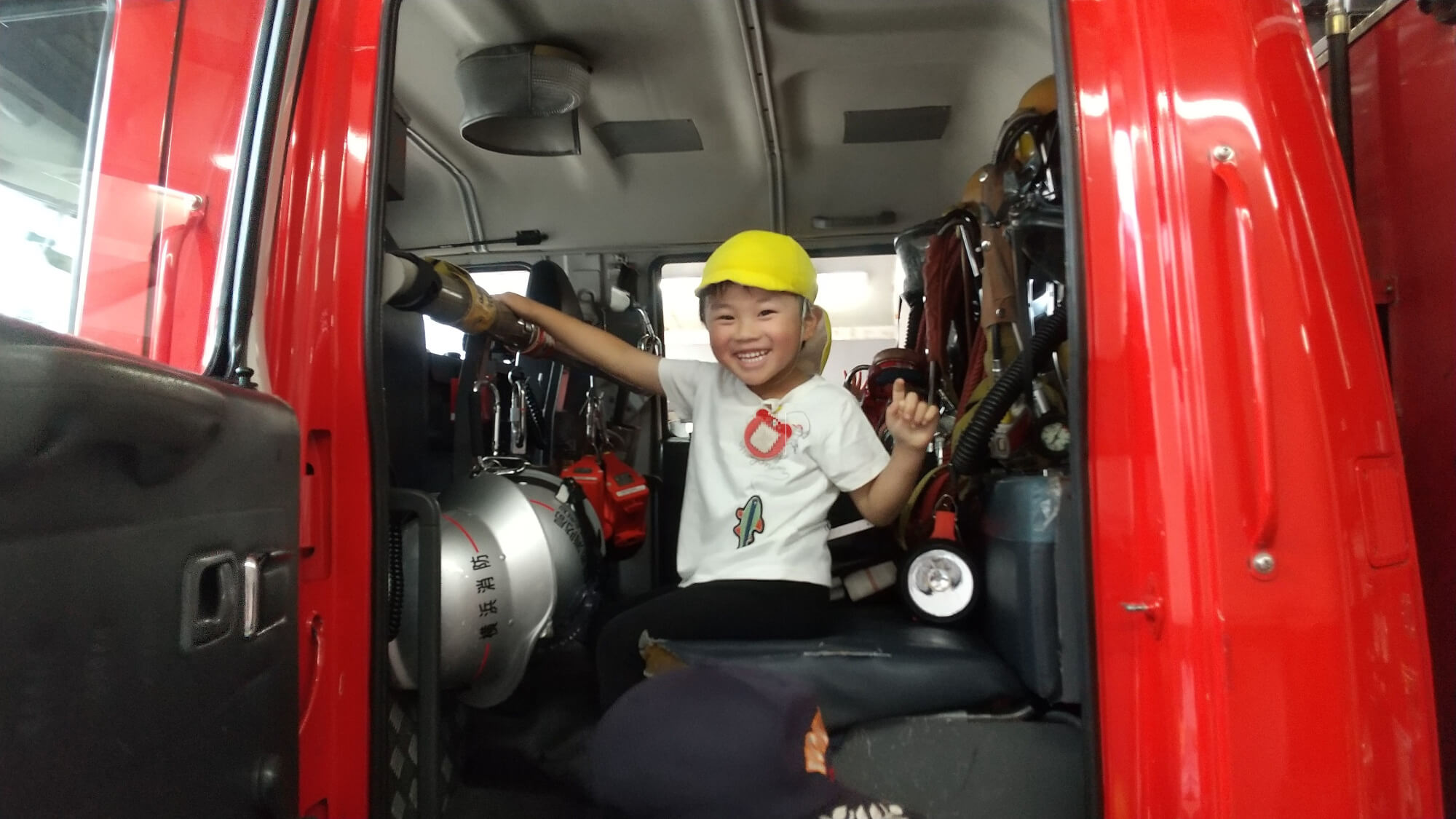 消防車に乗せてもらい笑顔になる子ども