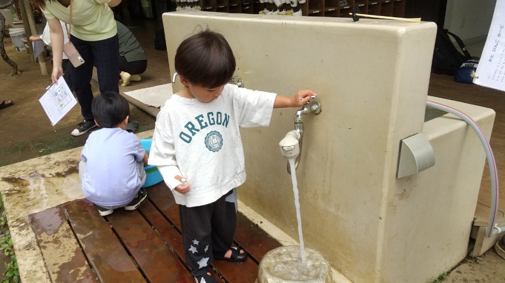 蛇口から水を出す子ども