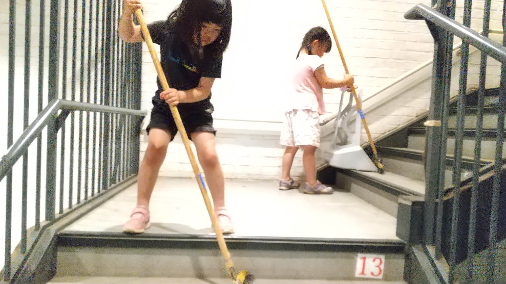 階段を掃除する子どもたち