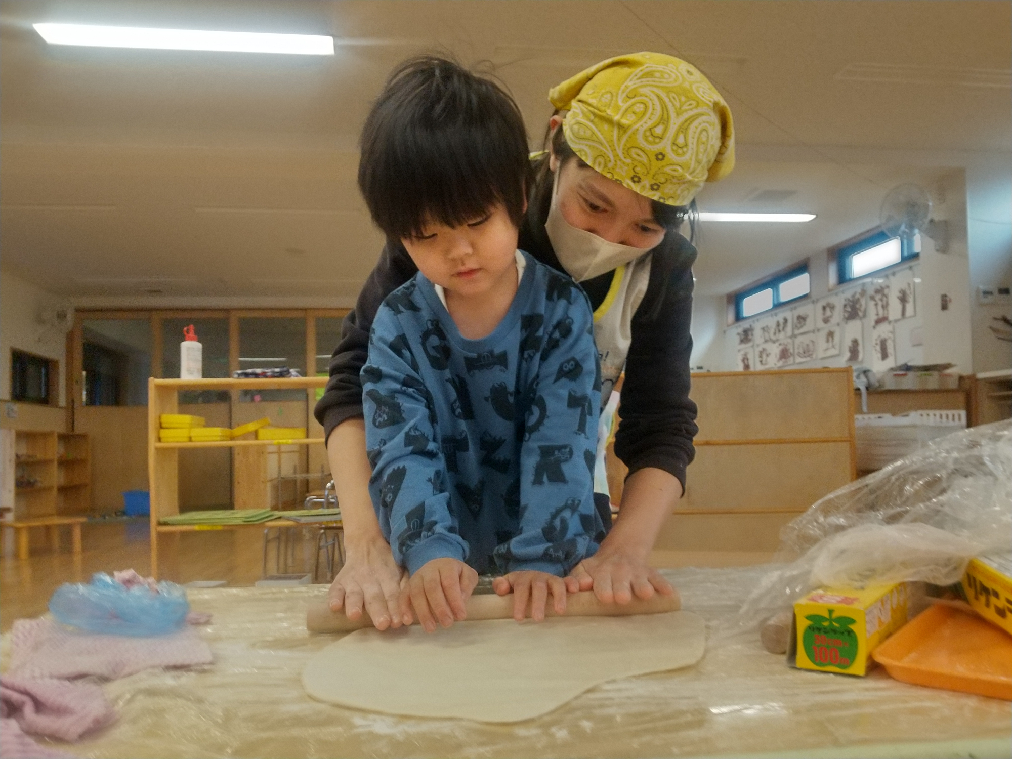 麺棒で生地を伸ばす子ども