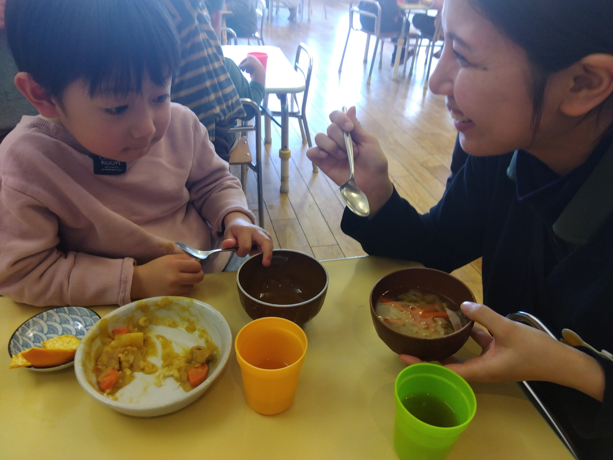 昼食を共にするスタッフと子ども