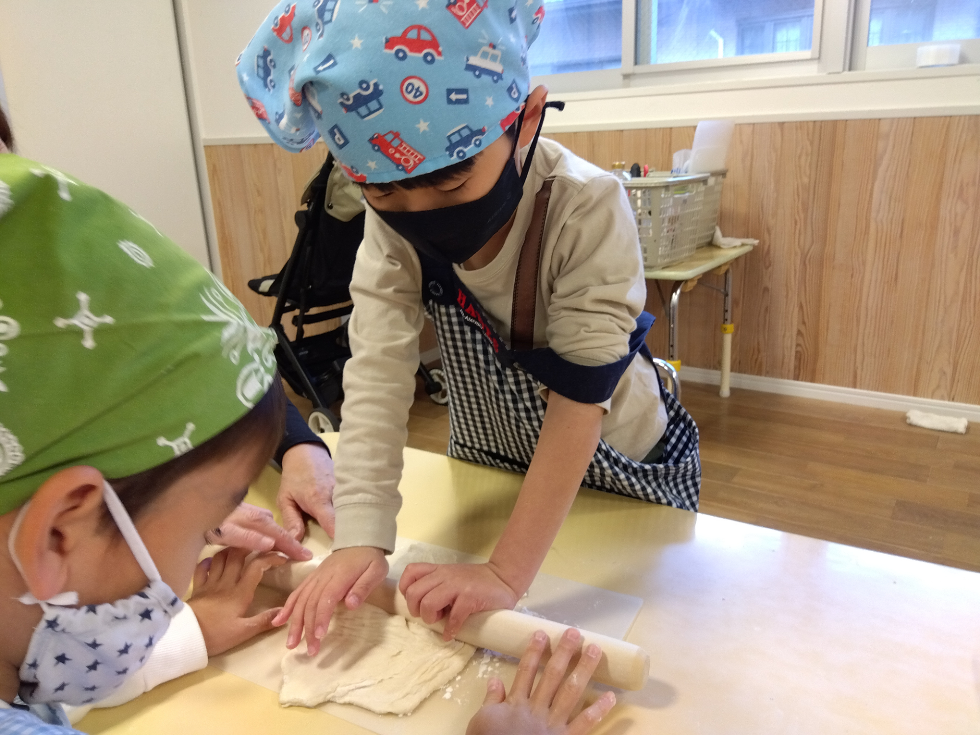 麺棒で生地を延ばす子ども